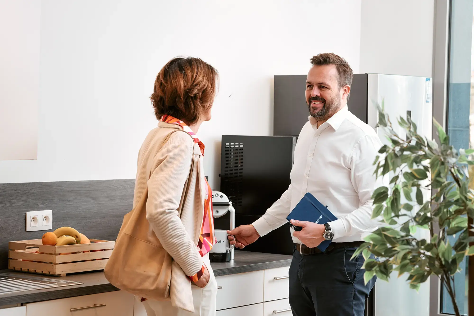 Deux collègues discutent dans la cuisine de l’entreprise Bluetime