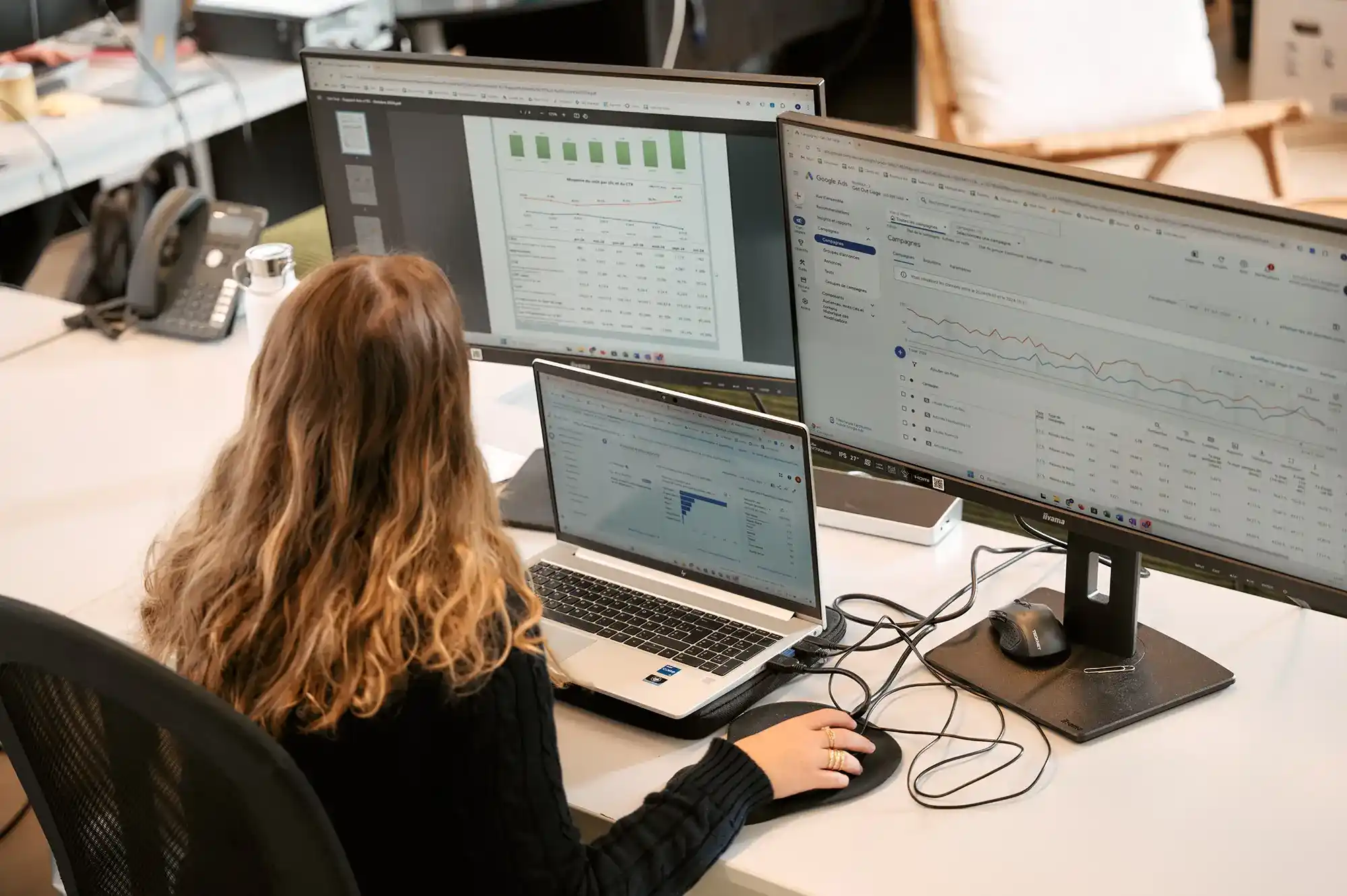 Experte SEA analysant des données sur trois écrans