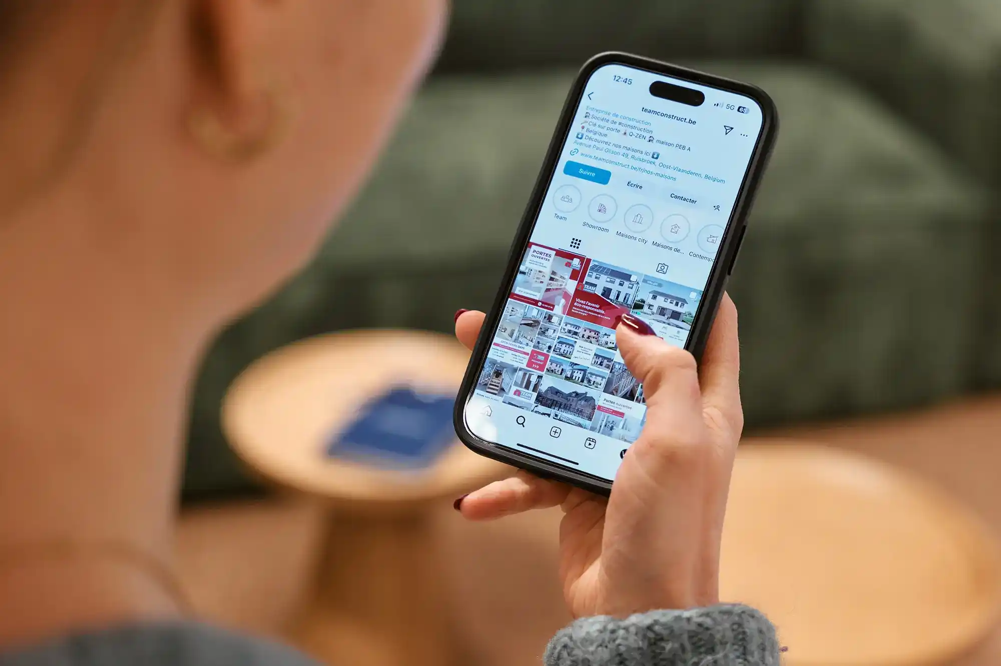 Zoom sur une main tenant un smartphone affichant un profil Instagram